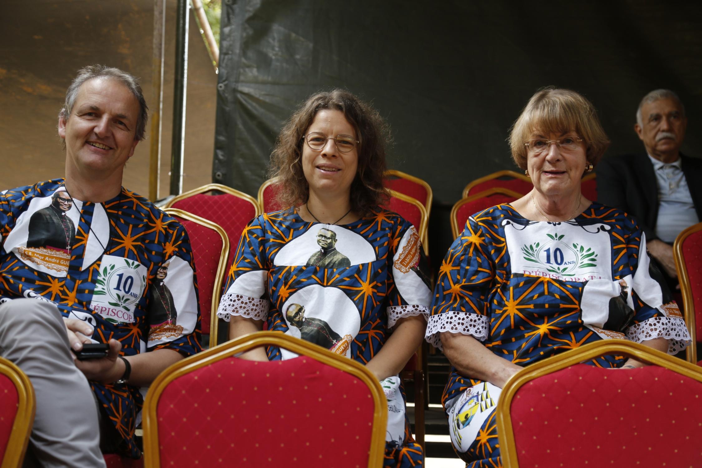 Im eigens für den Anlass im Senegal geschneiderten Outfit genießen die Bamberger das große Fest zum Bischofsjubiläum (v. li.): Michael Kleiner, Elisabeth Moser-Berner und Josef Weber.l)